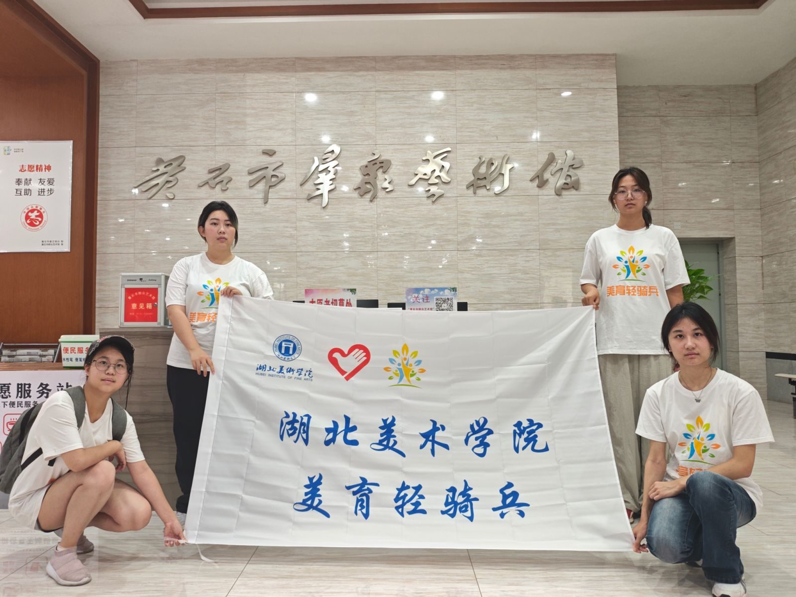 美育轻骑兵队员在黄石市群众艺术馆持队旗合影
